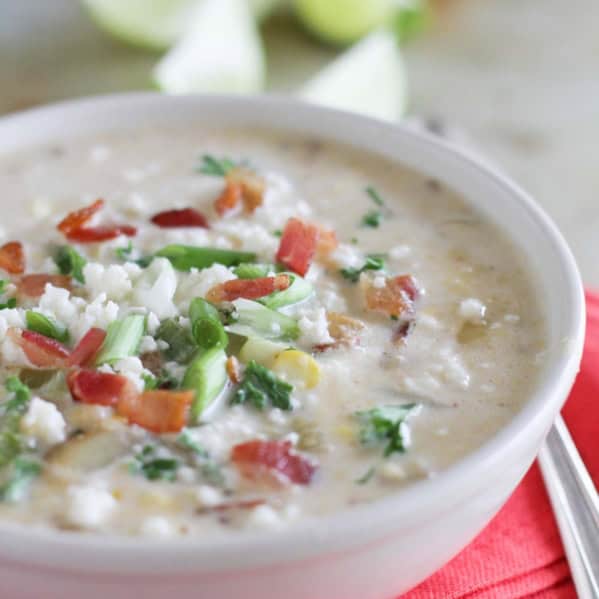 Bowl of Chipotle Corn Chowder topped with bacon, green onions, and cheese.