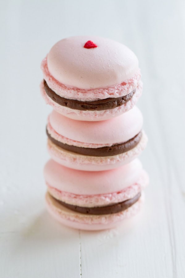 Three Chocolate Cherry French Macarons stacked on top of each other.