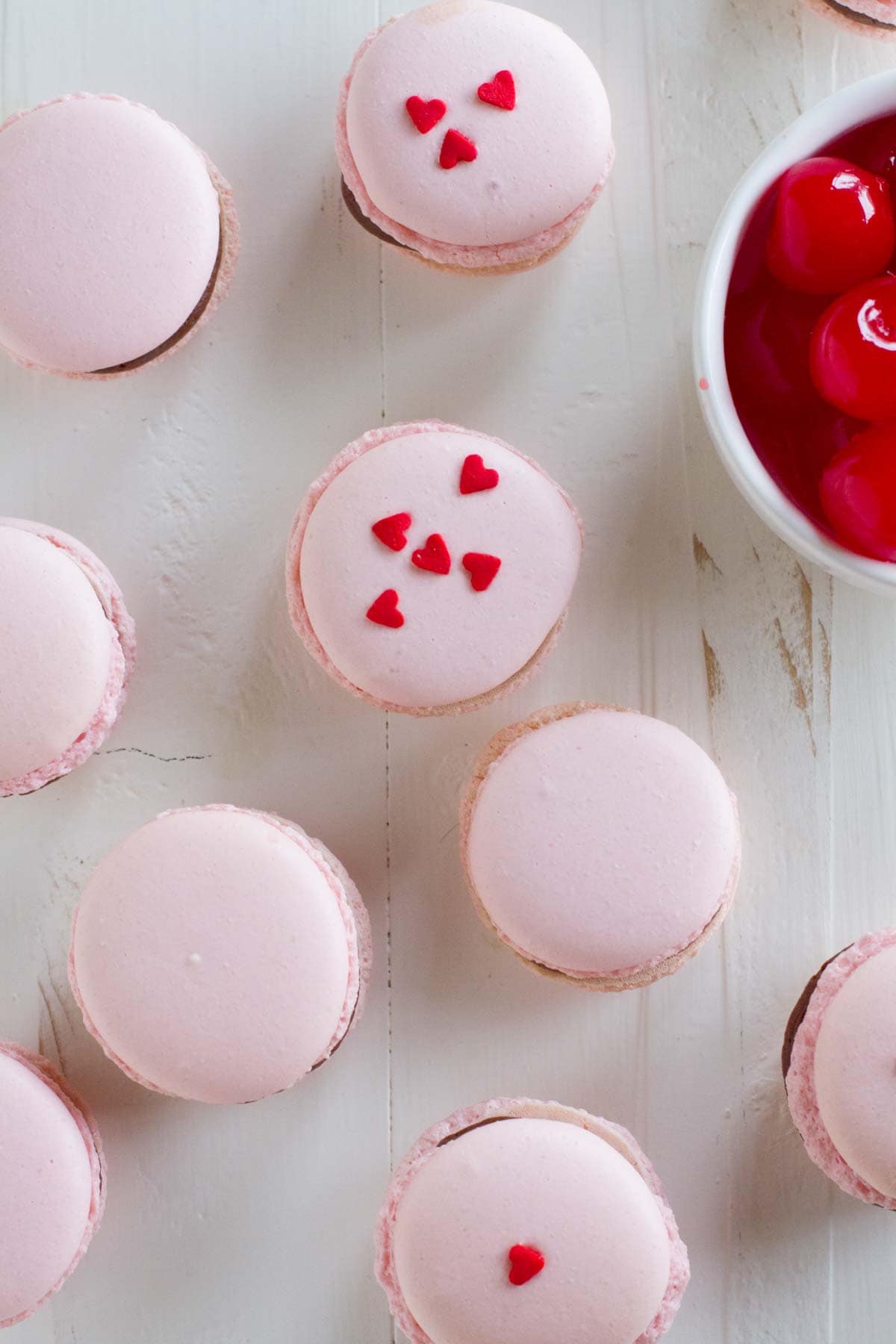 Chocolate Cherry French Macarons, with heart sprinkles on top of some.