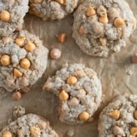 Oatmeal Scotchies on parchment paper with a bite taken from one.