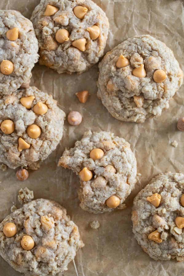 Oatmeal Scotchies on parchment paper with a bite taken from one.