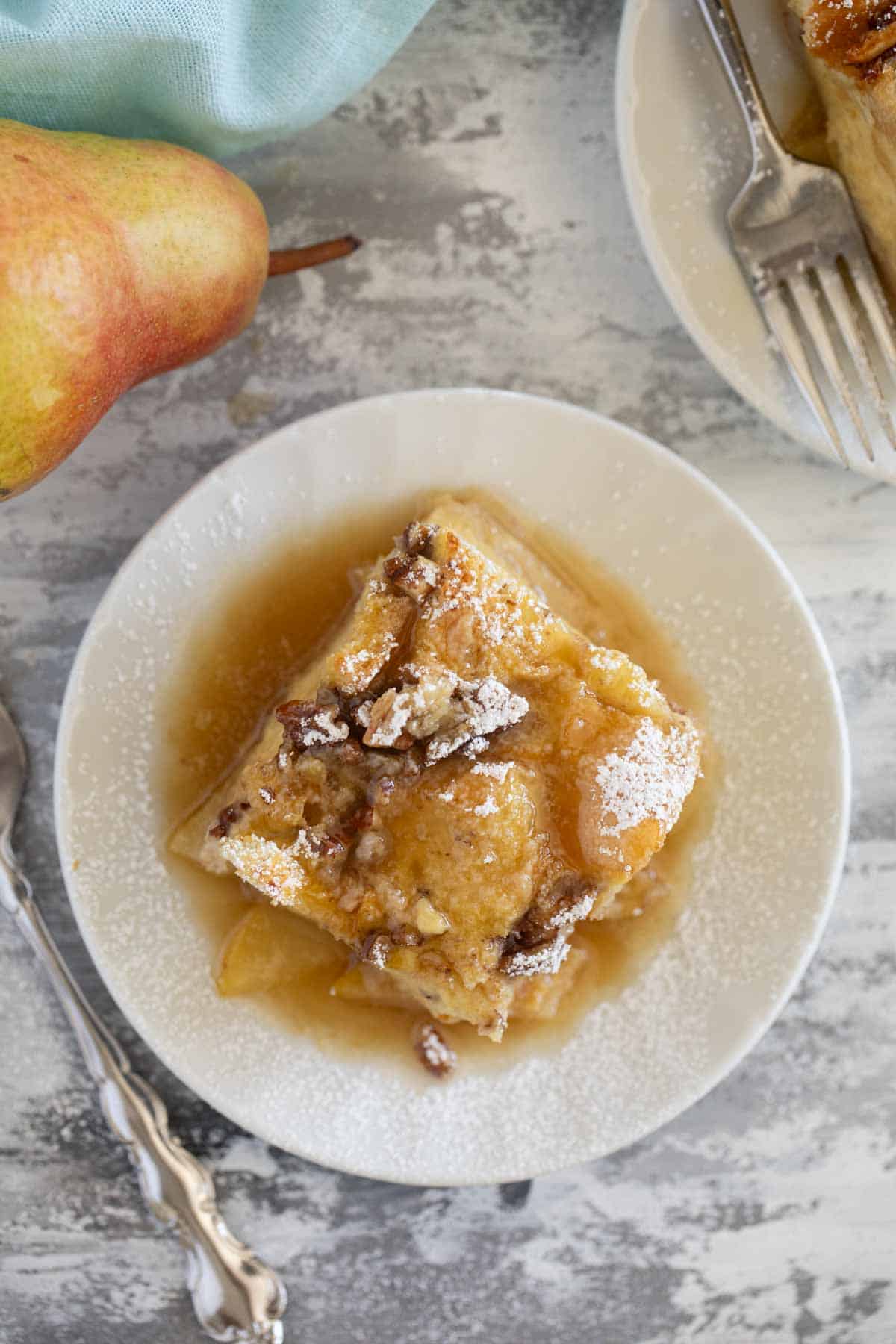 Slice of Pear Baked French Toast on a plate with powdered sugar on top.