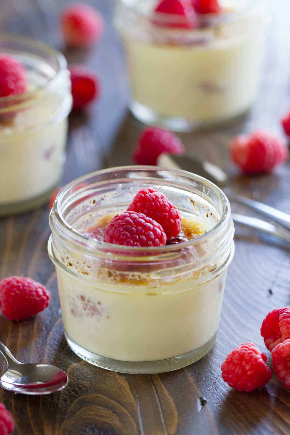 Raspberry Creme Brûlée topped with fresh raspberries in a jar.