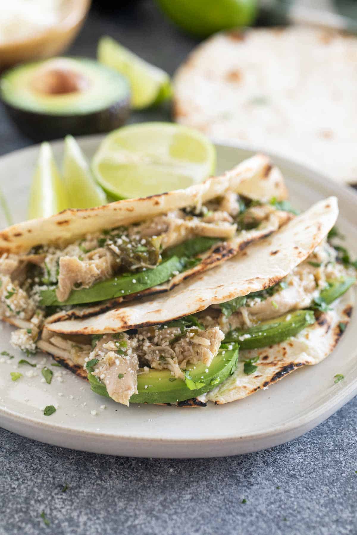 Słów Cooker Chicken Tacos with avocado and cilantro.