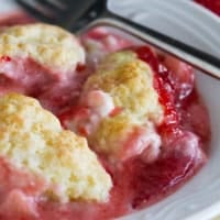 Serving of Strawberry Cobbler with Cream Cheese in a shallow bowl.