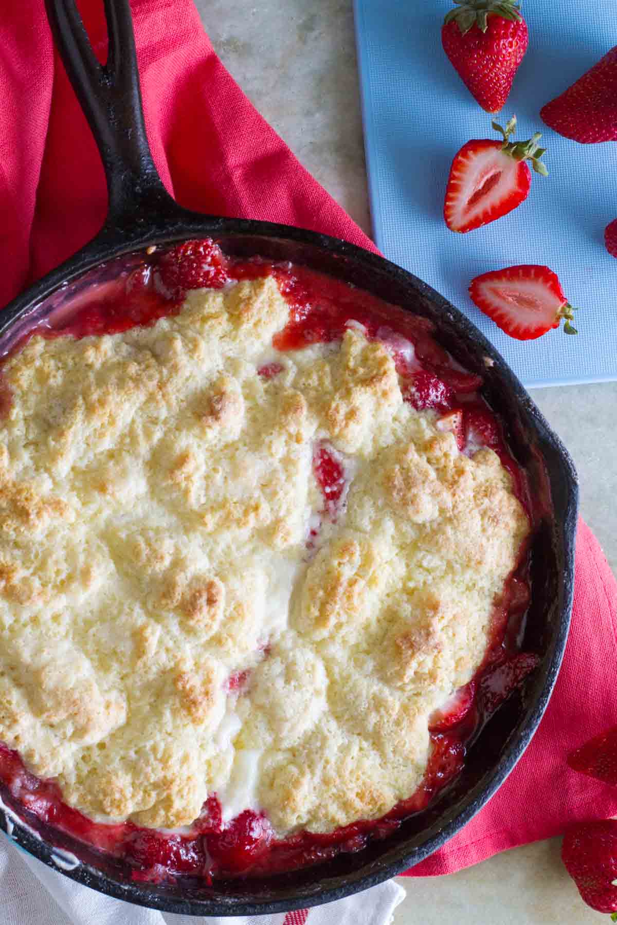 Cast iron skillet filled with Strawberry Cobbler with Cream Cheese.