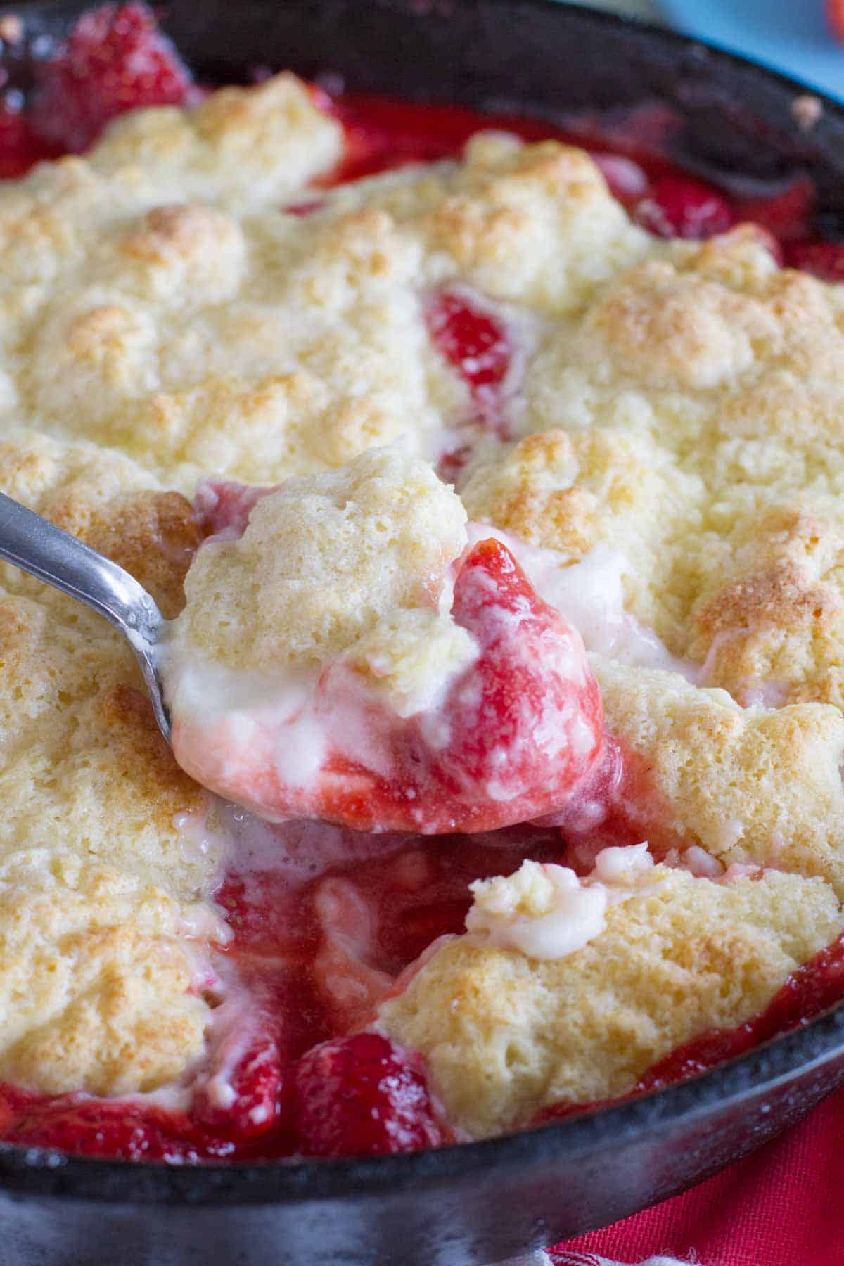 Scooping out a spoon full of Strawberry Cobbler with Cream Cheese.