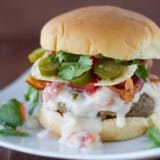 Tex-Mex Bacon Cheeseburgers with queso sauce, jalapeños, and corn chips.