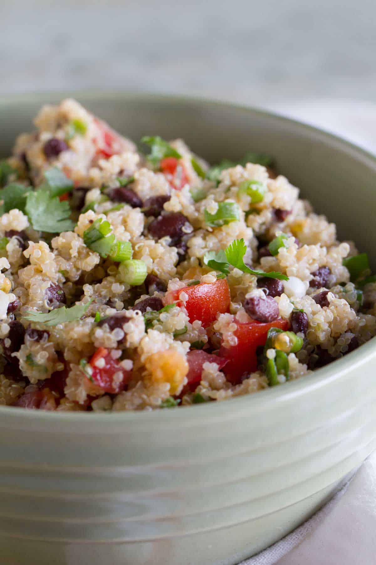 Tomato and Black Bean Quinoa Salad with green onions and cilantro on top.