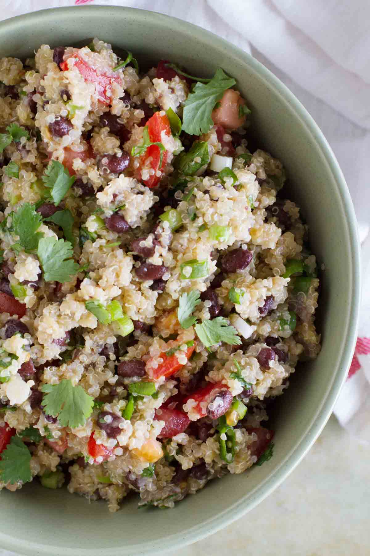 Green bowl filled with Tomato and Black Bean Quinoa Salad.