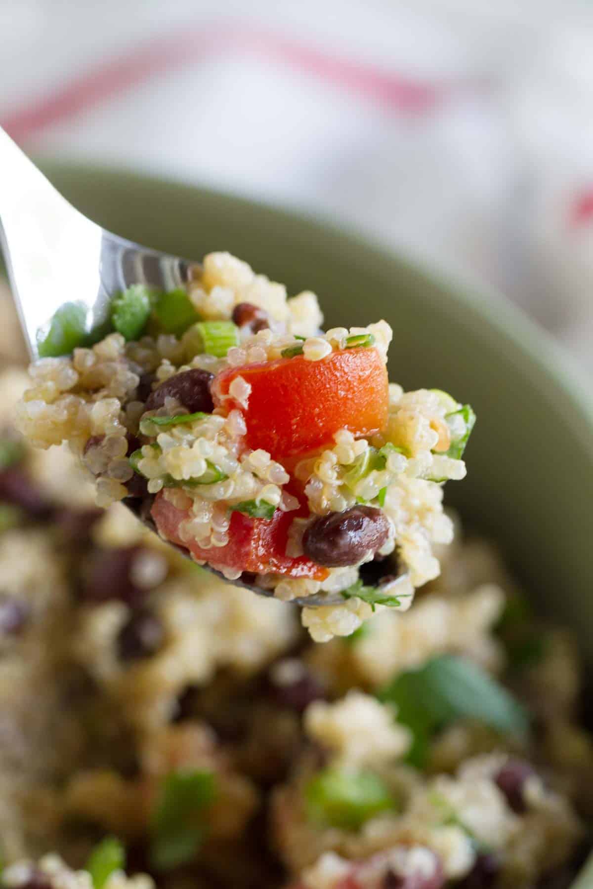 Spoon filled with Tomato and Black Bean Quinoa Salad.