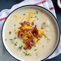 Bowl of Baked Potato Soup, topped with bacon, cheese, and chives.