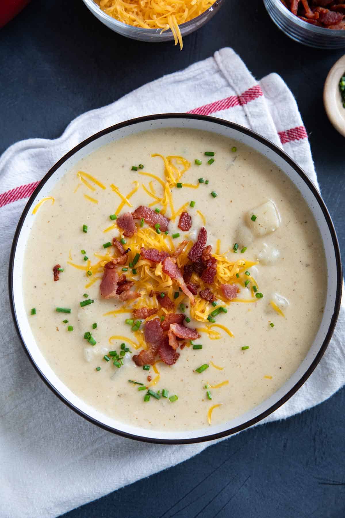 Bowl of Baked Potato Soup, topped with bacon, cheese, and chives.