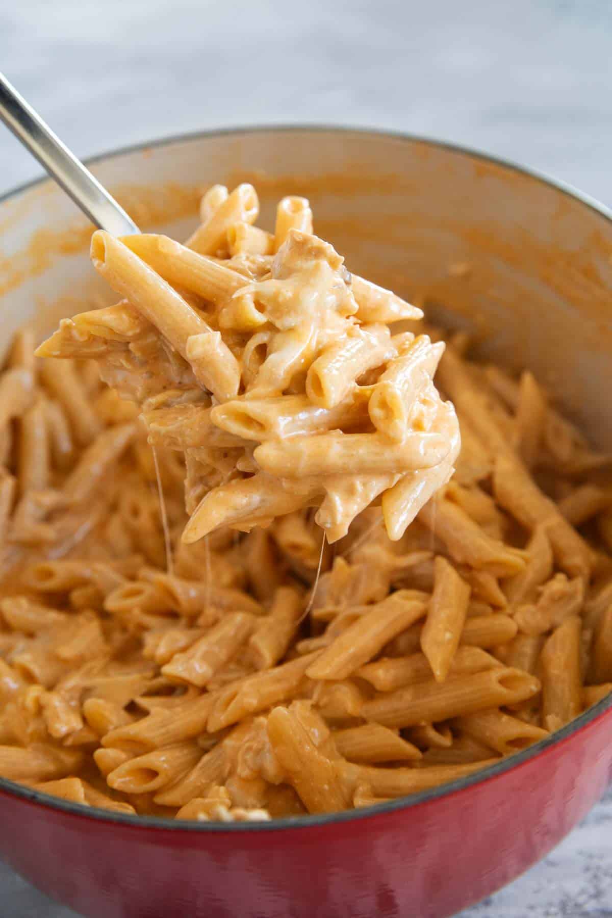 Large spoon with a scoop of buffalo chicken pasta.