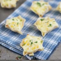 Cheesy Corn Bites topped with cilantro, on a towel over a baking sheet.