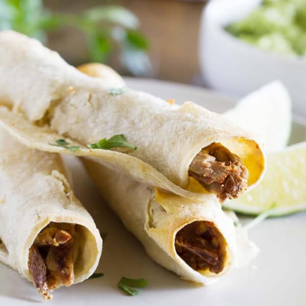 Chipotle Beef Baked Taquitos stacked on a plate.