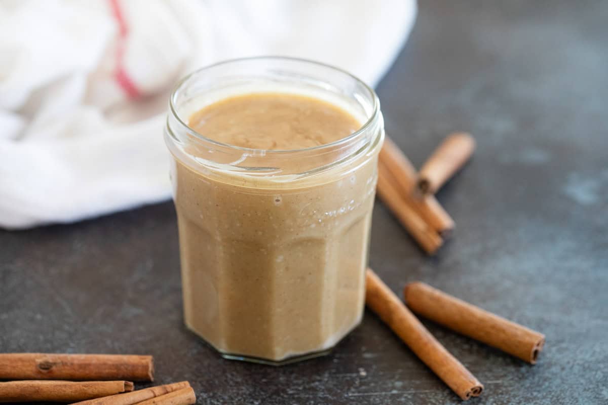 Cinnamon Syrup in a small jar with cinnamon sticks next to it.