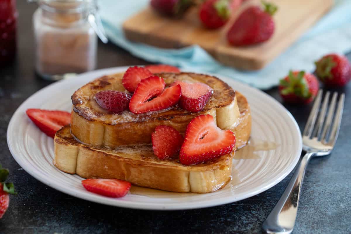 French Toast served with sliced berries and syrup.