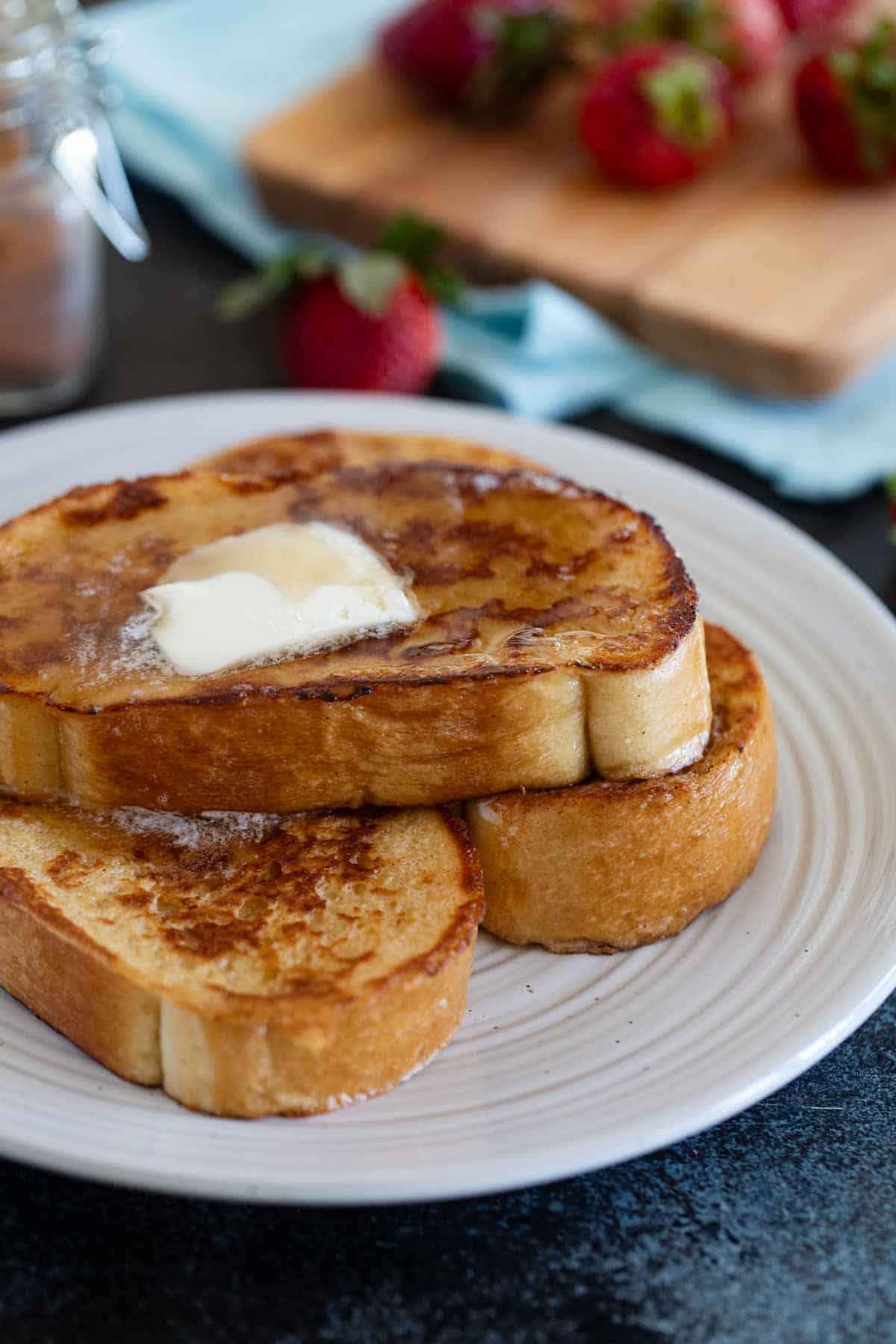 Slices of French Toast topped with syrup and butter.