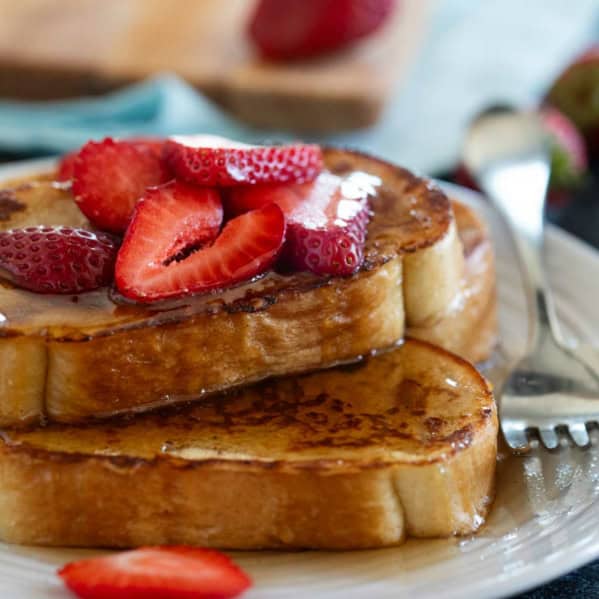 Slices of French Toast topped with syrup and berries.