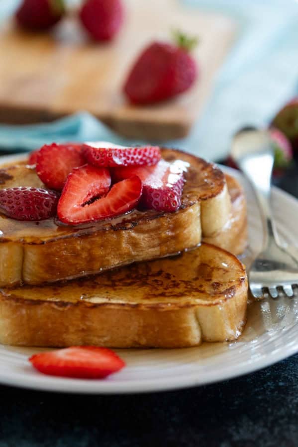 Slices of French Toast topped with syrup and berries.