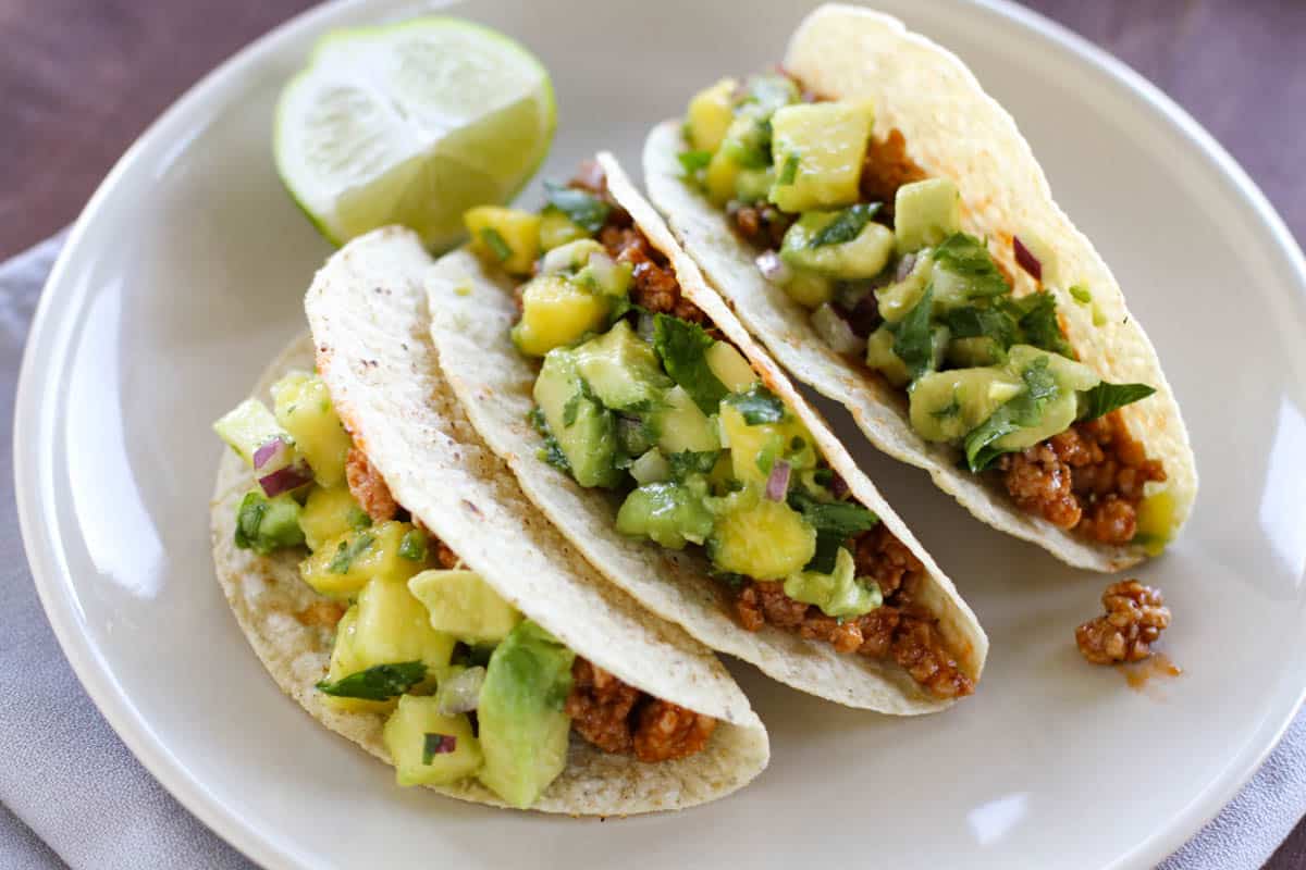 Hawaiian Tacos with ground pork, topped with a salsa made with pineapple, mango, and avocado.