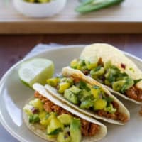 Three Hawaiian Tacos on a plate with a slice of lime.