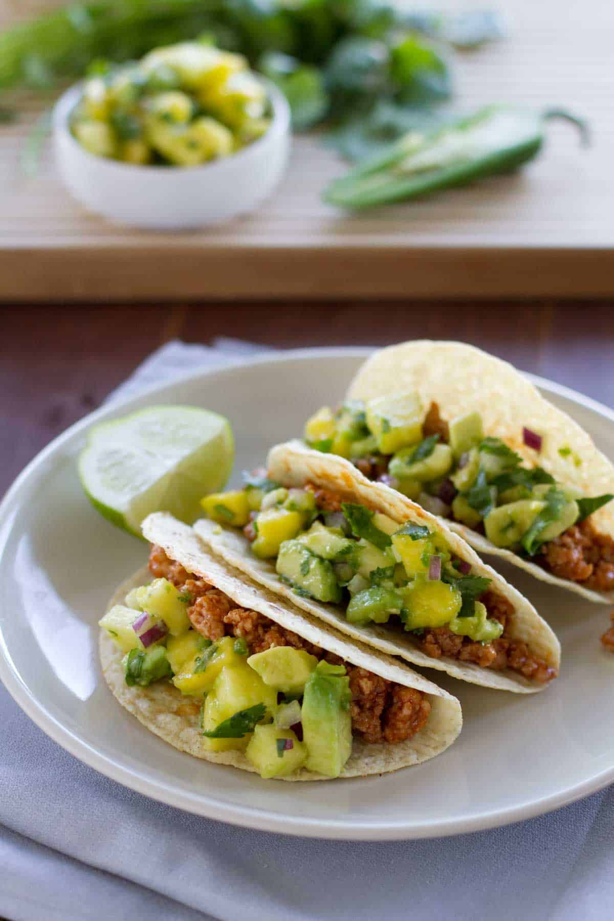 Three Hawaiian Tacos on a plate with a slice of lime.