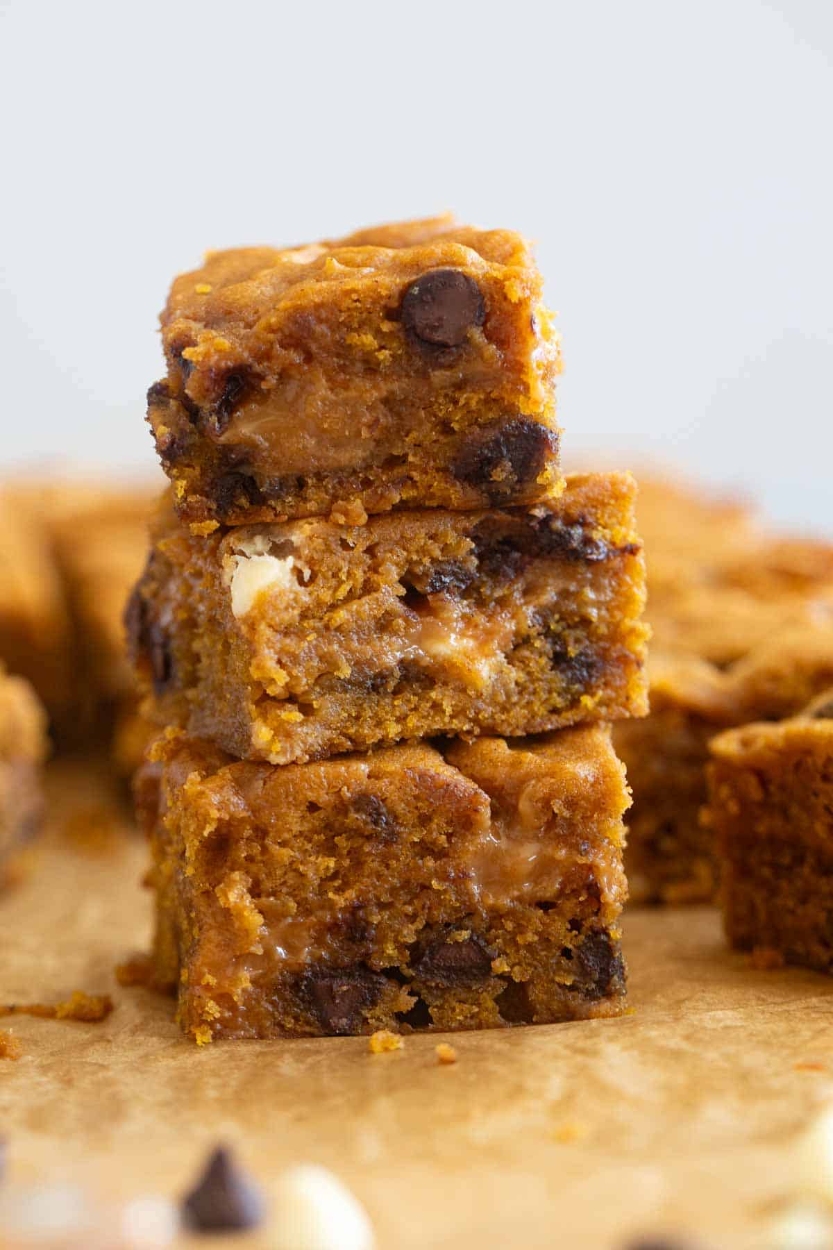 Three loaded caramel pumpkin blondies stacked on top of each other.