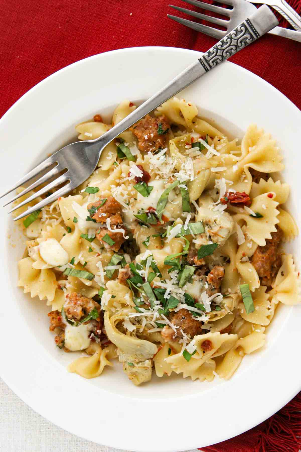 Pasta with Sausage, Artichokes, and Sun-Dried Tomatoes in a shallow bowl.