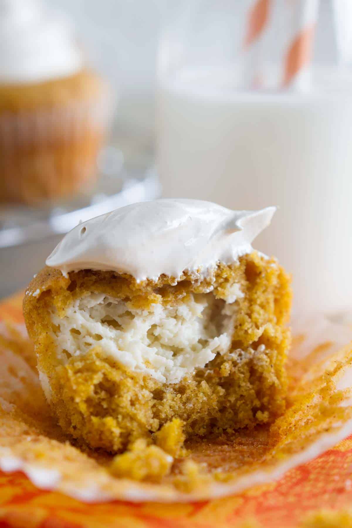 Pumpkin cheesecake cupcake torn in half to show cream cheese filling.