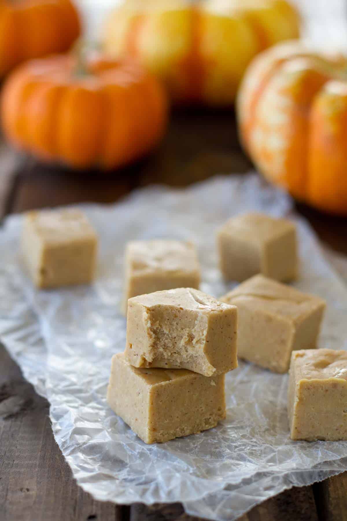 Stacked pumpkin fudge with a bite taken out of one piece.