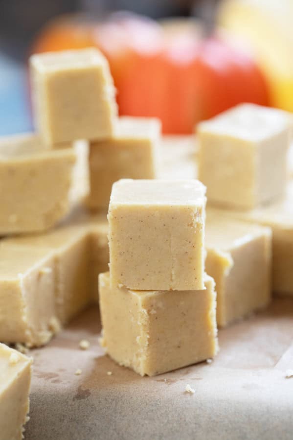 Squares of pumpkin fudge with some stacked on each other.