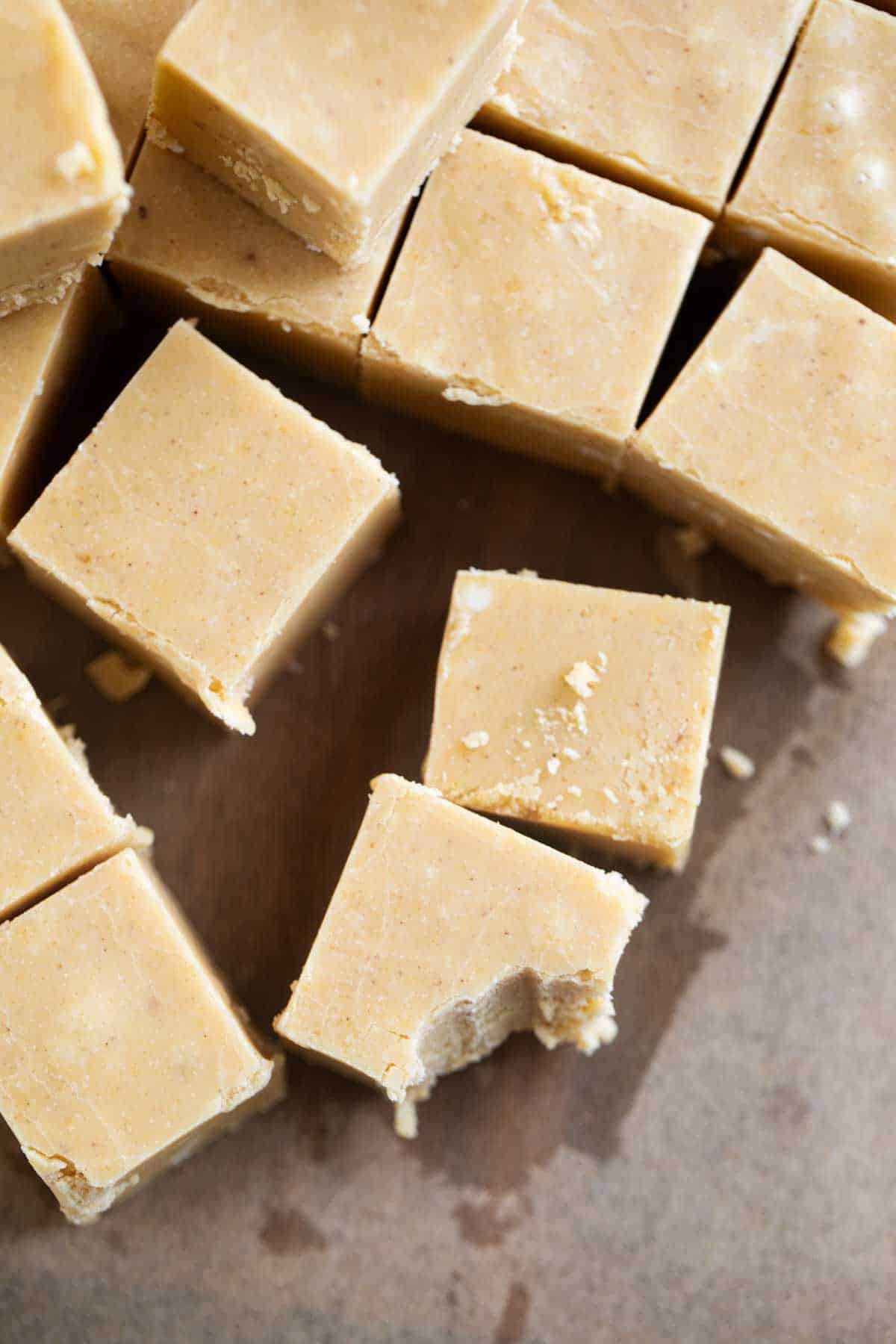 Pumpkin Fudge cut into squares, with a bite taken from one piece.