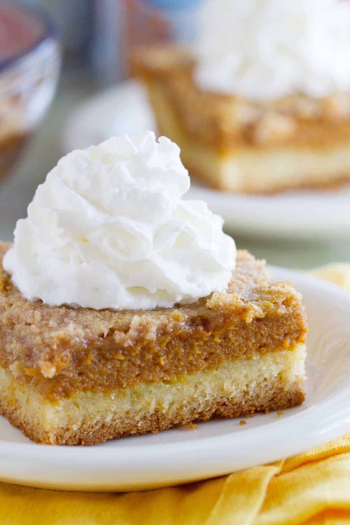 Slice of Pumpkin Pie Cake topped with a dollop of Reddi-Wip.