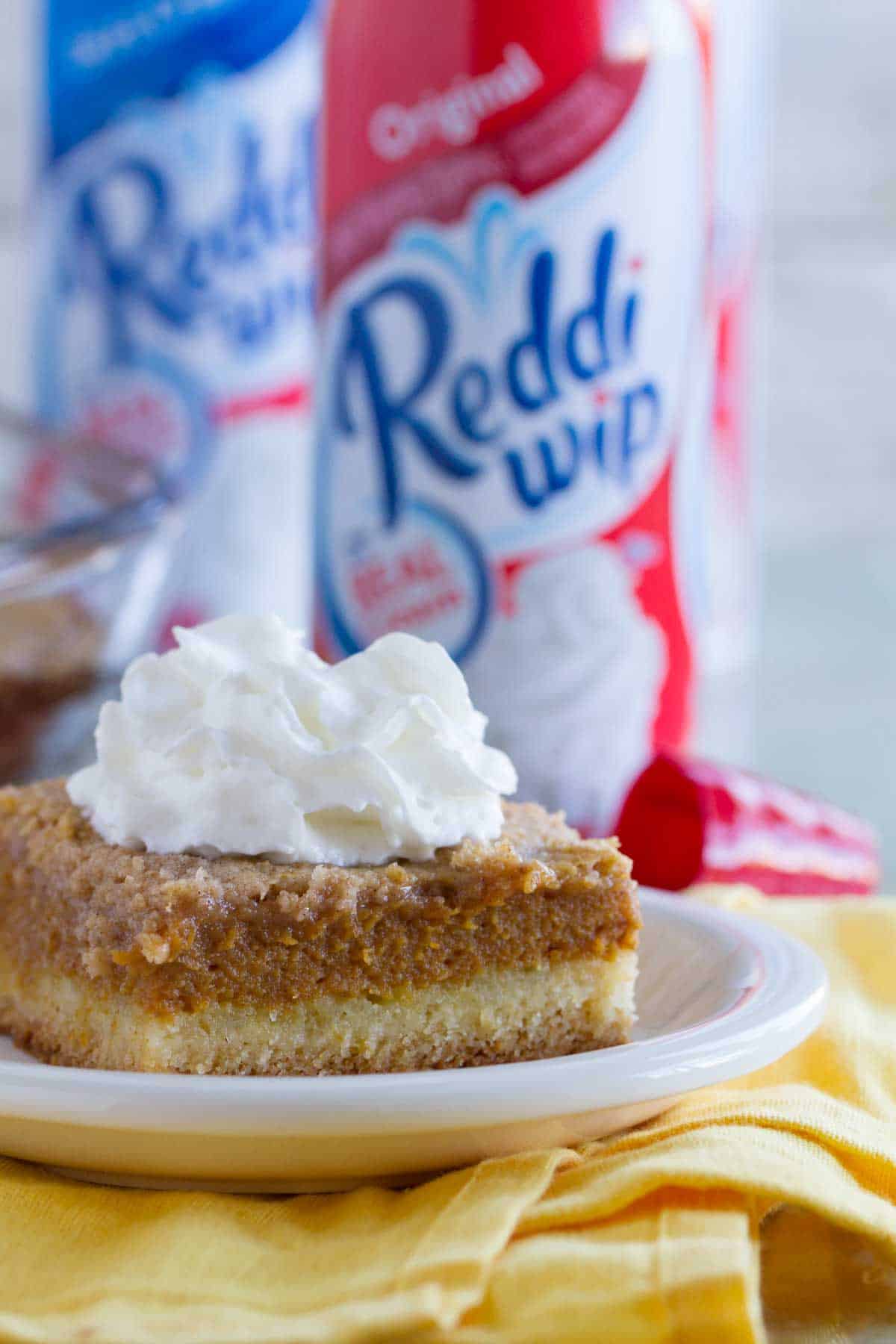 Slice of pumpkin pie cake on a plate that is on a yellow towel.