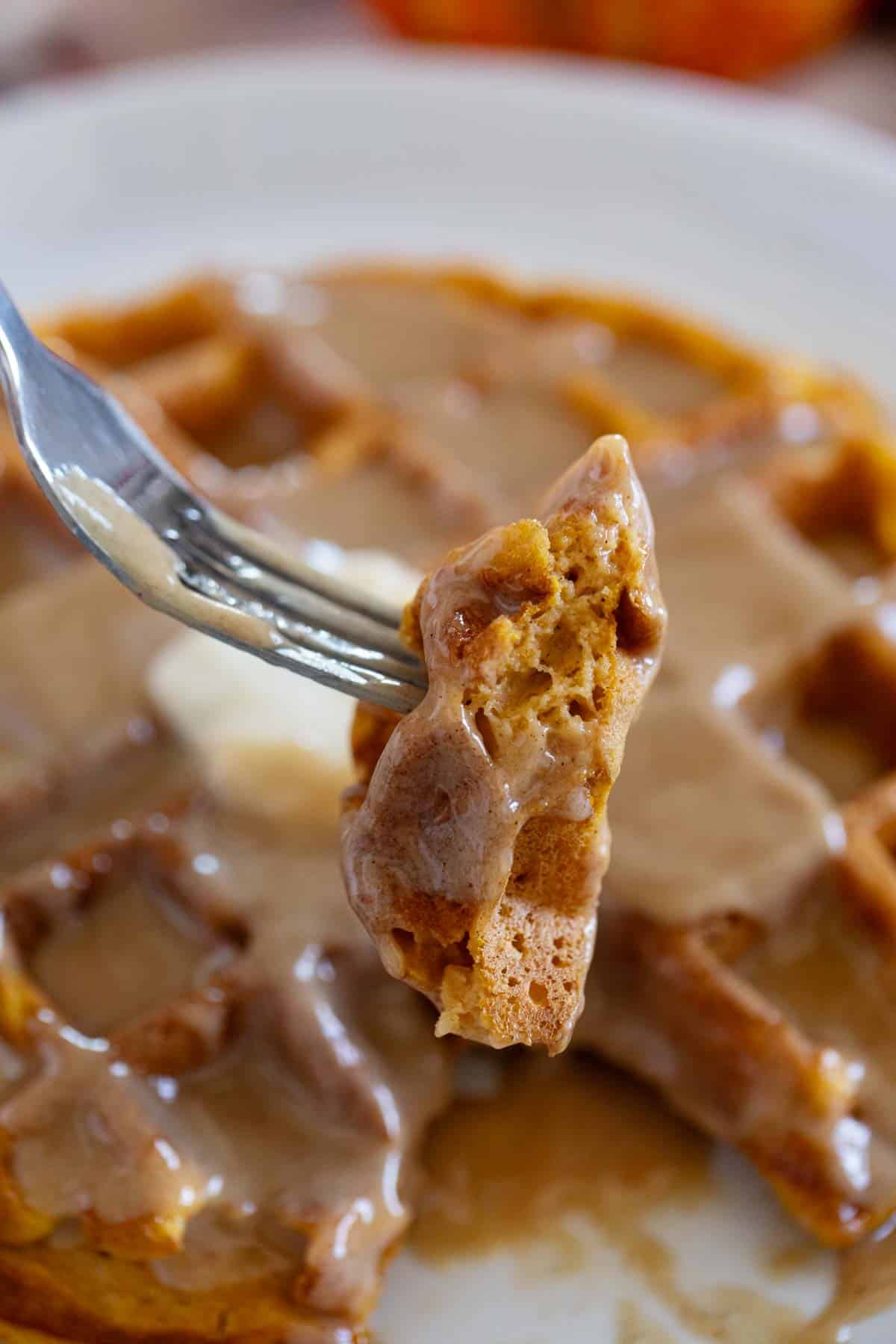 Bite of pumpkin waffle on a fork to show interior texture.