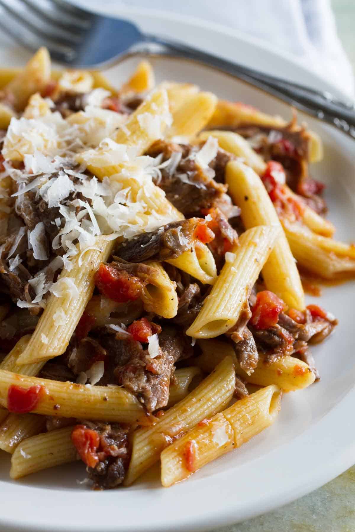 Slow Simmered Short Rib Sauce with Pasta on a plate, with freshly grated parmesan on top.