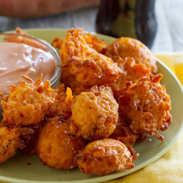 Sweet Potato Tots on a plate, with a bowl of creamy ketchup next to it.