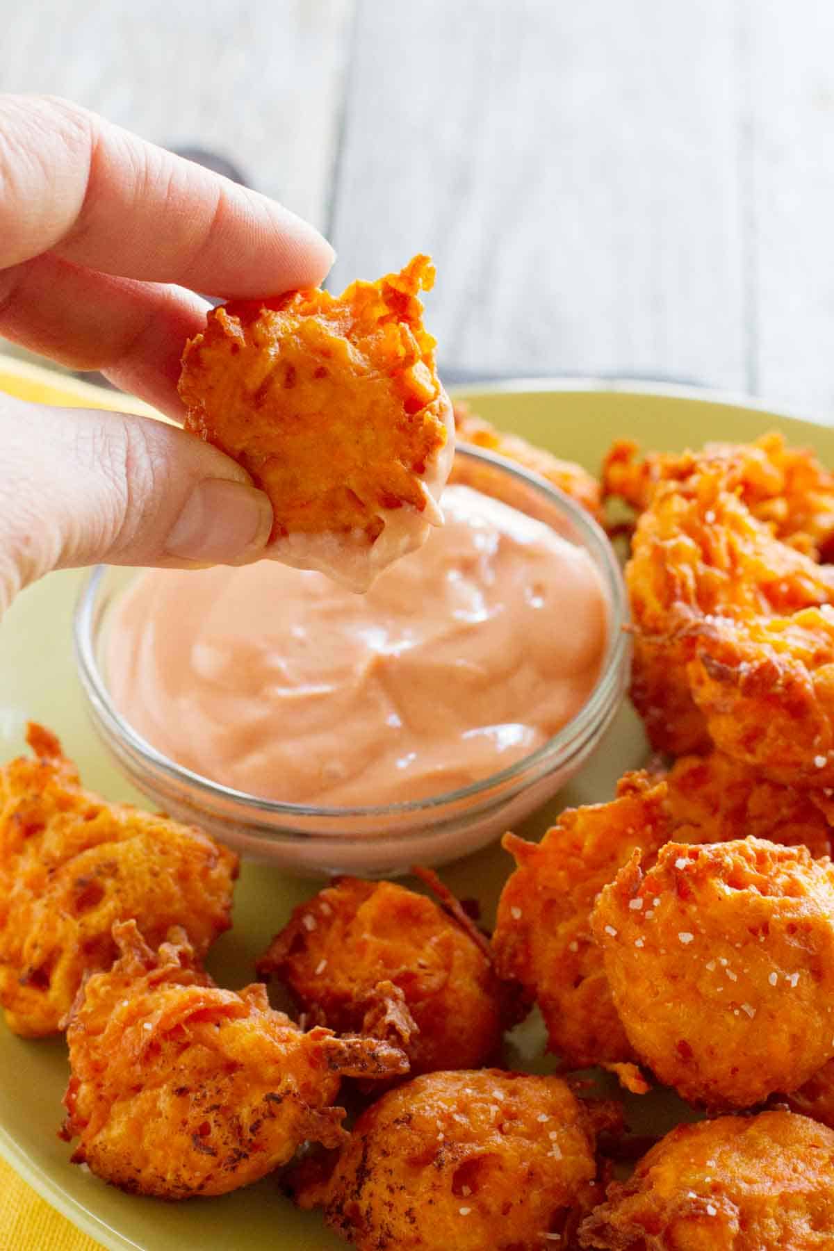 Dipping a sweet potato tot into creamy ketchup.