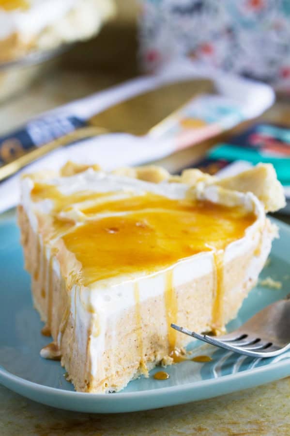 Slice of white chocolate caramel no bake pumpkin pie on a plate with a fork.