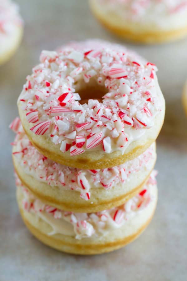 Three baked peppermint donuts stacked on top of each other.