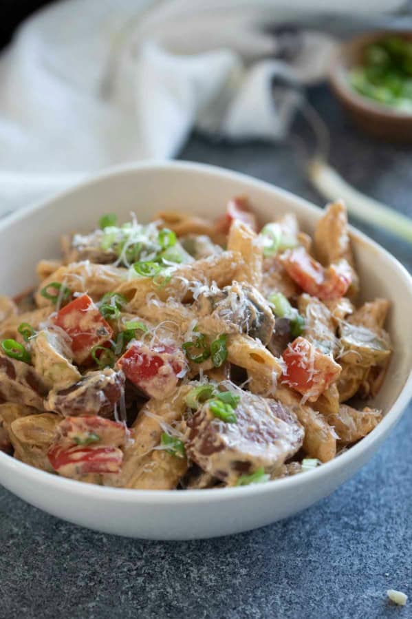 Bowl filled with Cajun Sausage Pasta topped with parmesan cheese.