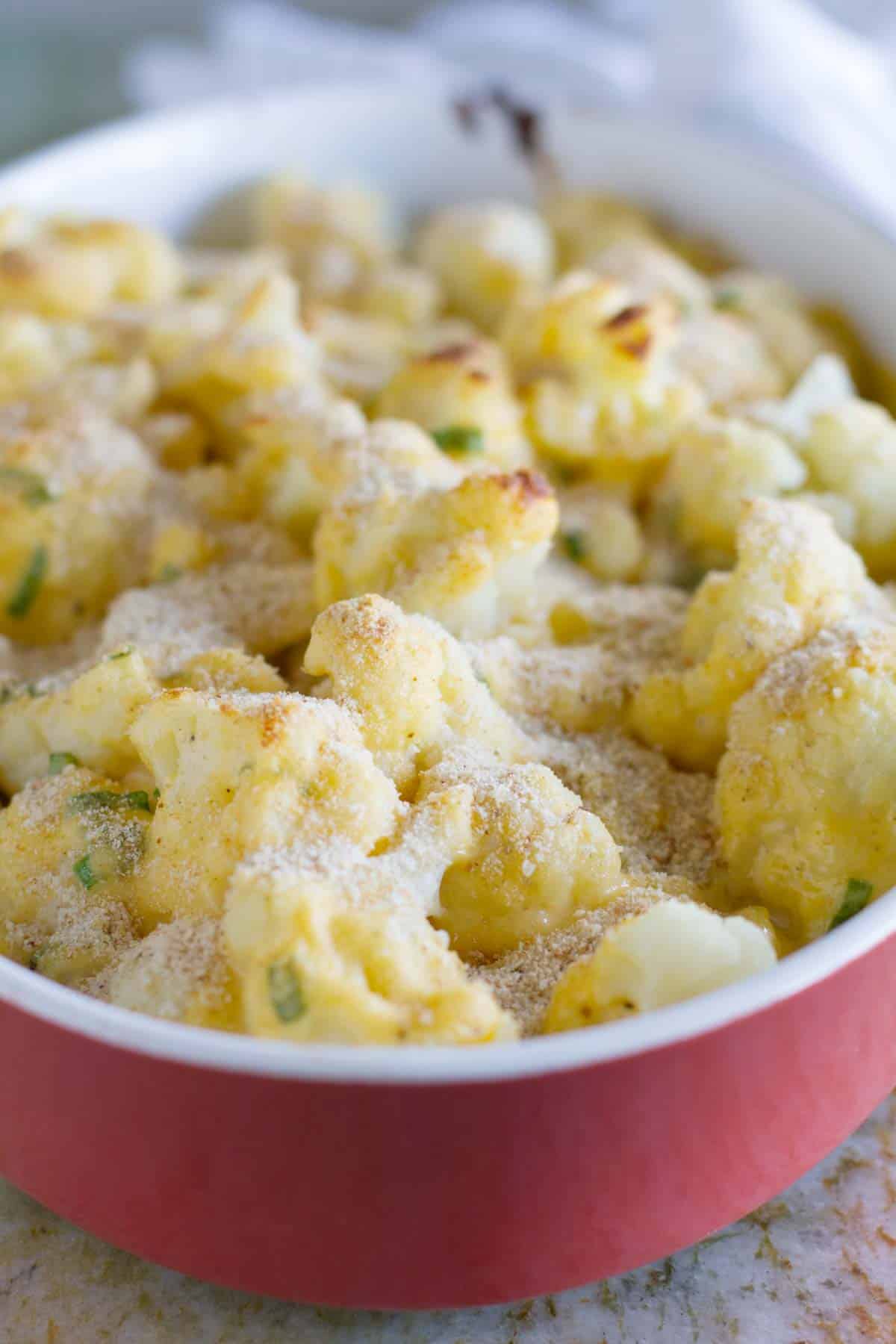 Baking dish filled with Cheddar Cauliflower Gratin topped with breadcrumbs.