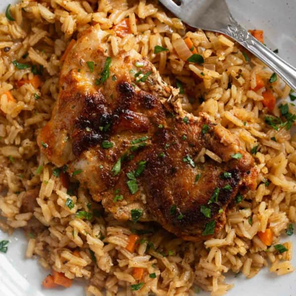 Chicken and Rice on a plate, topped with chopped parsley.