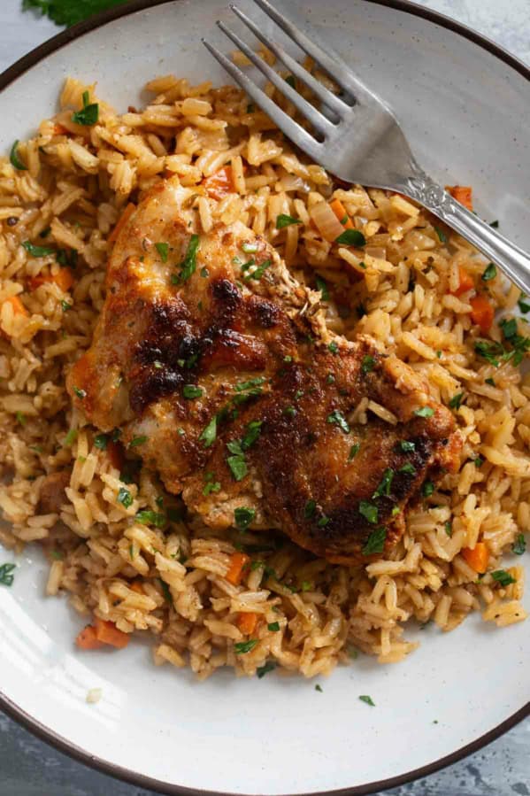 Chicken and Rice on a plate, topped with chopped parsley.