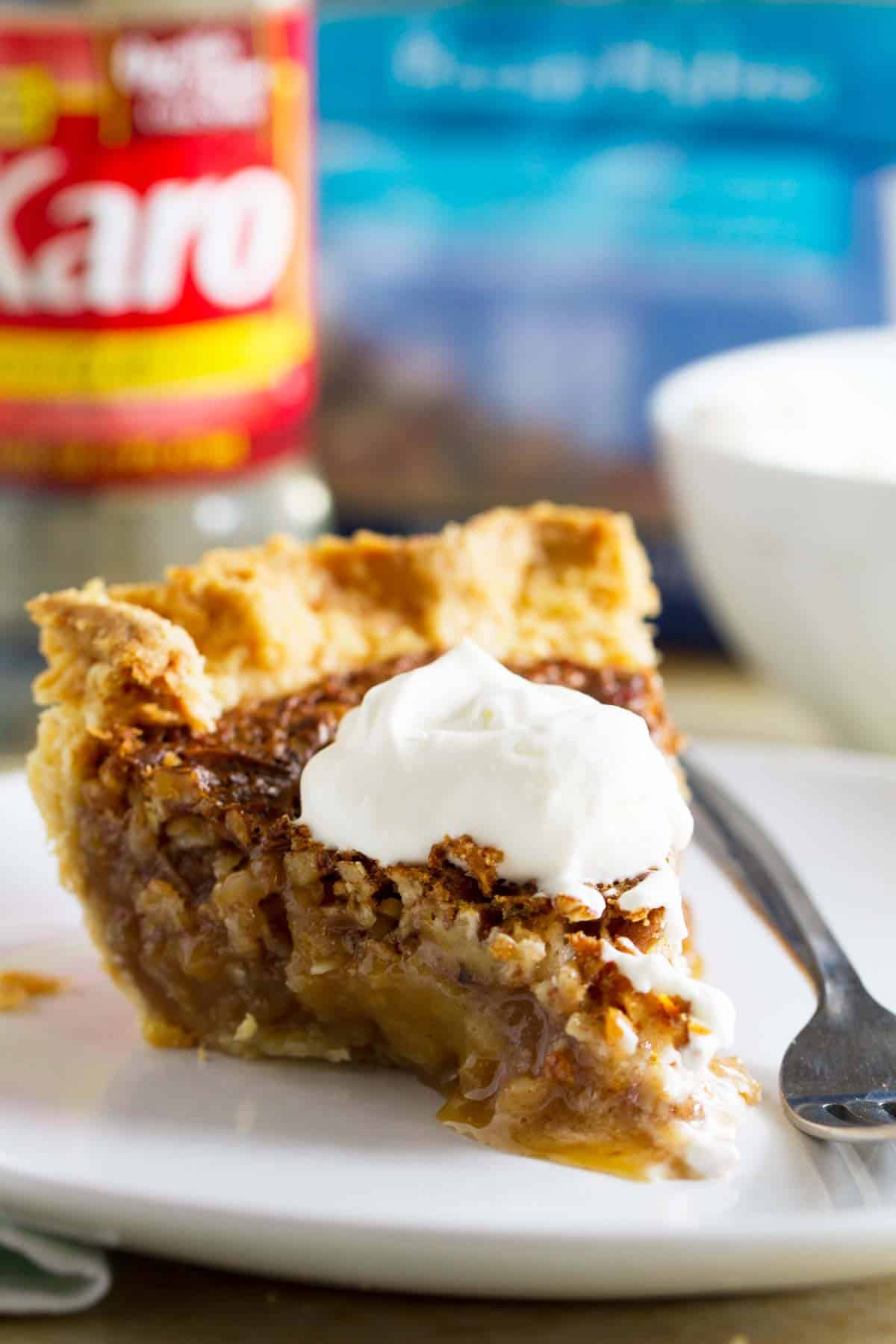 Slice of coconut pecan pie topped with whipped cream.