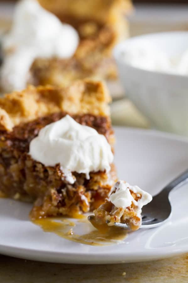 Fork full of coconut pecan pie on a plate.