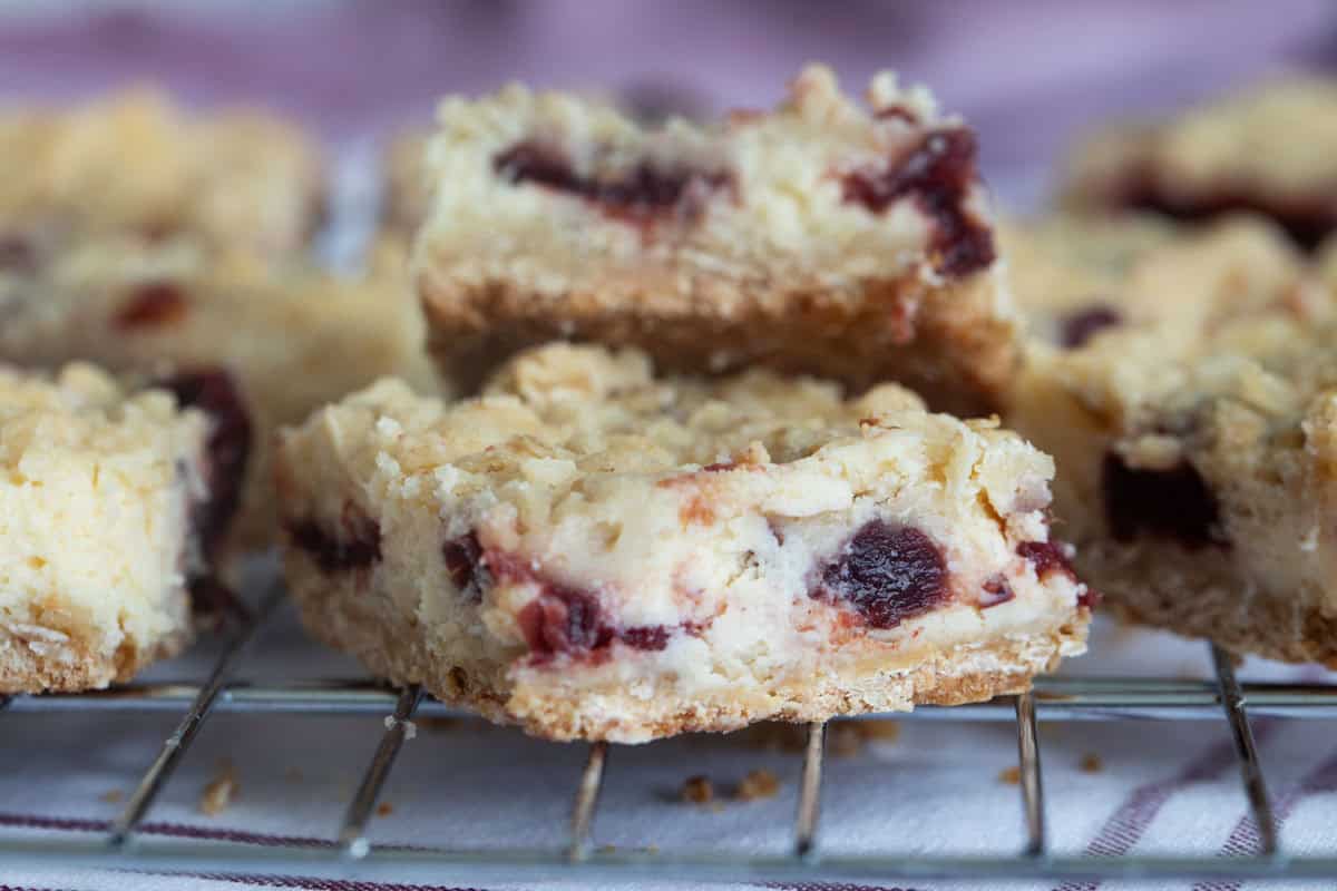 Cranberry Cheesecake Bars with an oat crust, cheesecake filling, cranberry filling, and crumble topping.