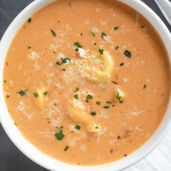 Bowl of Creamy Tortellini Soup topped with parmesan cheese.